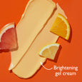 Pale yellow gel cream swatch with grapefruit and orange slices on orange background.