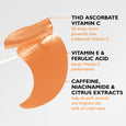 Orange crescent-shaped gel eye patch with ingredient callouts for vitamin C, vitamin E, ferulic acid, caffeine, niacinamide, 