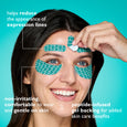 Person wearing teal peptide-infused tape strips on forehead and under eyes, with one strip being applied by hand.