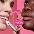 White lip plumping tube being applied to lips of two people with different skin tones against pink background.