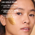 Woman with dark hair wearing a gold-colored face mask applied to her cheek, showing skin texture and natural complexion.