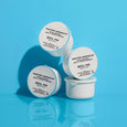 Three white circular refill pods labeled "Water Drench Hyaluronic Jelly Moisturizer" arranged on a blue background.
