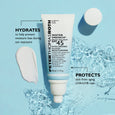 White tube of Water Drench SPF 45 moisturizer with hyaluronic acid displayed on light blue background with water splashes and