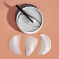 White gel patches in two shapes—curved eye patches and larger oval face patches—with applicator brush in open container.