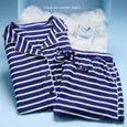 Navy and white striped pajama set with matching top and shorts, displayed with skincare packet on cloud background.